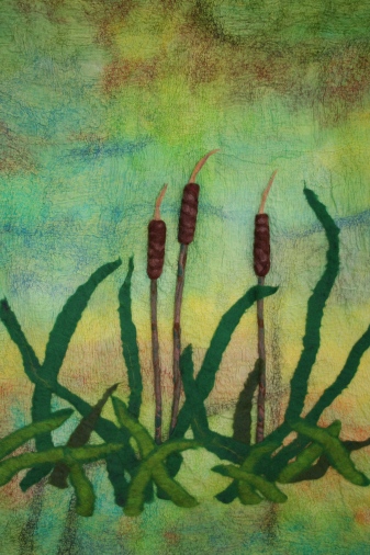 Felt wall hanging of three bulrushes against a mottled background