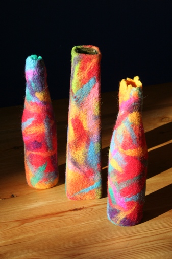 Three multicoloured felt vessels in strong sunlight